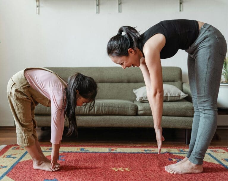 mother and daughter stretching in living room