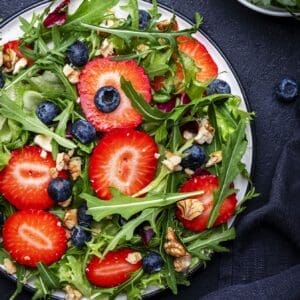 Fresh strawberry and herb salad on a white plate