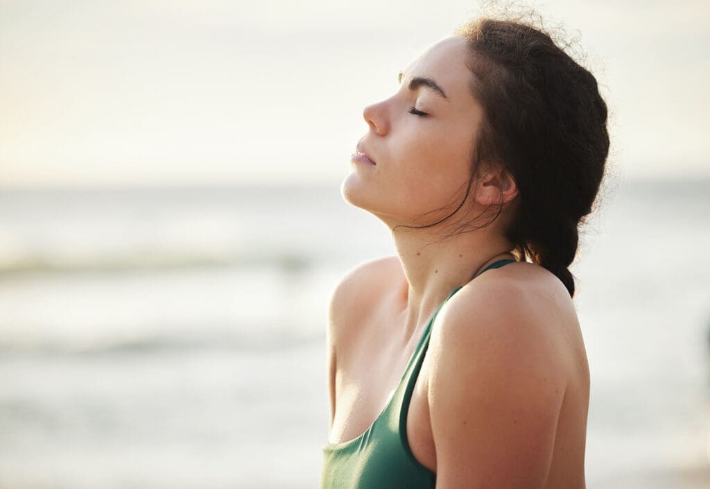 Woman relaxes and clears her mind near the ocean